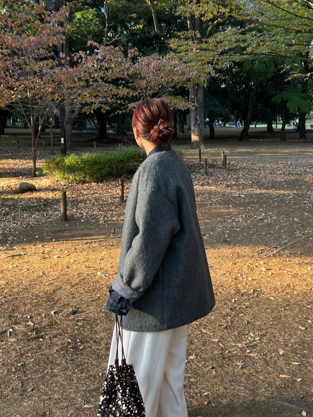 ブラウン系のショルダーバッグ、グレー系のノーカラーコート、ブルー系のデニムジャケットを着用したレディースの秋コーディネートの2枚目の写真