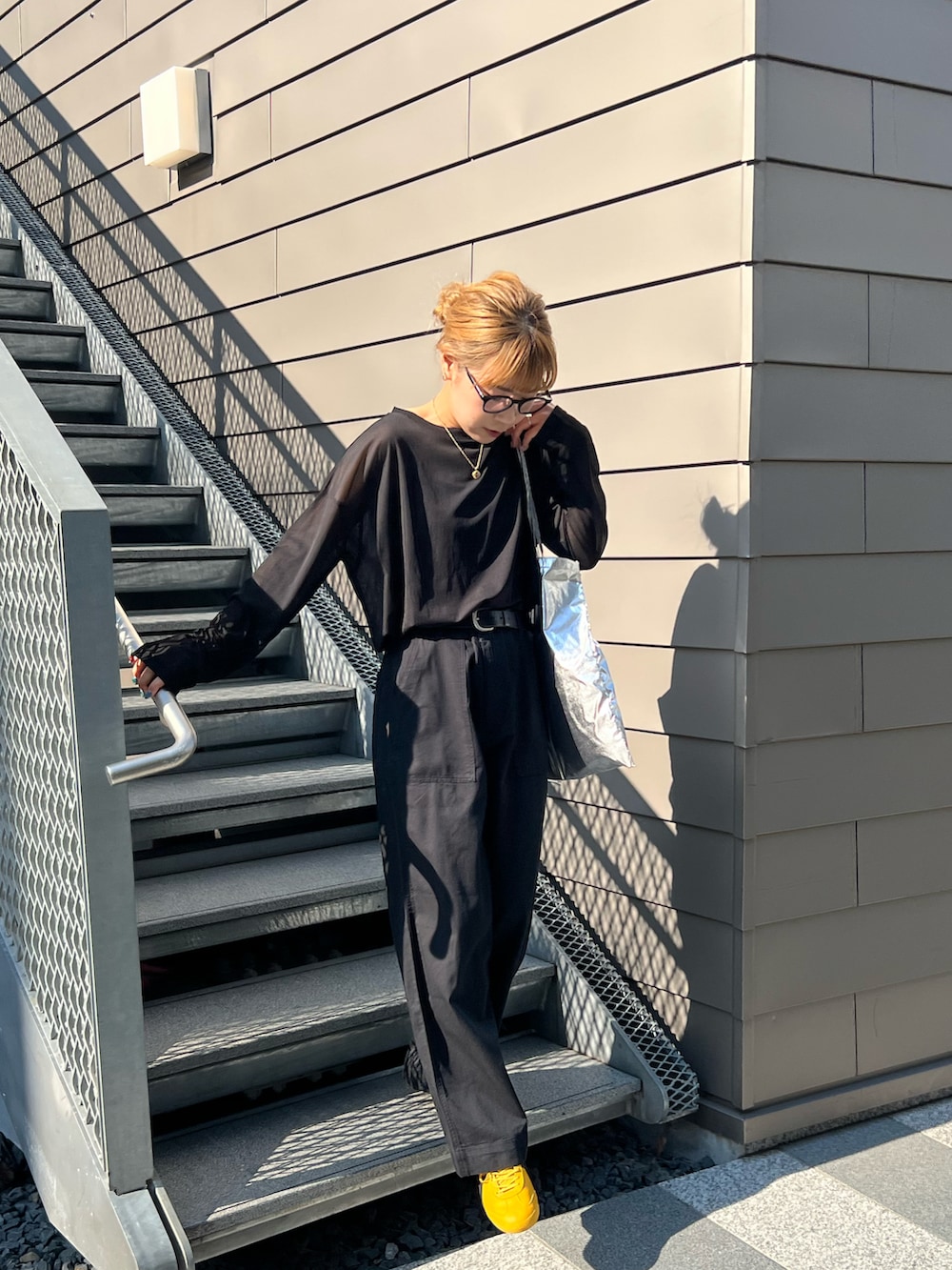 ブラック系のTシャツ/カットソー、ブラック系のチノパンツを着用したレディースの春コーディネートの2枚目の写真