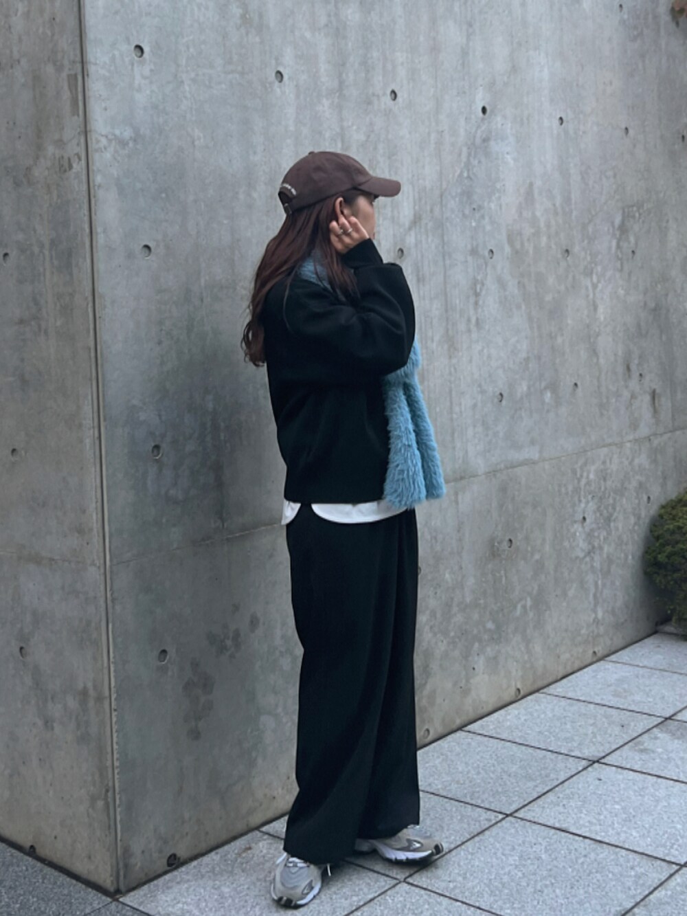 ブラック系のニット/セーター、ブラック系のパンツ、グレー系のスニーカーを着用したレディースの秋コーディネートの5枚目の写真