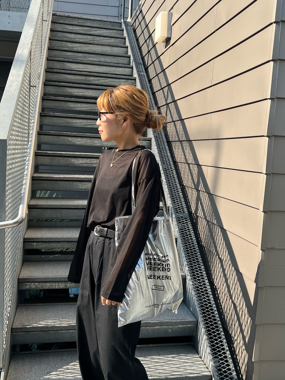 ブラック系のTシャツ/カットソー、ブラック系のチノパンツを着用したレディースの春コーディネートの4枚目の写真