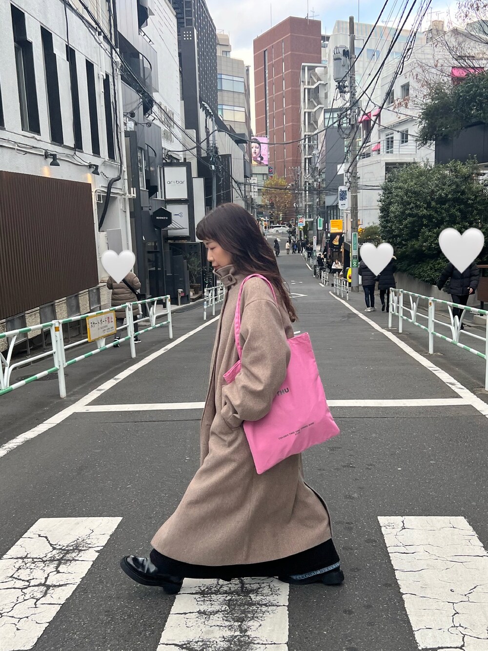 ブラウン系のステンカラーコート、ブラック系のワンピースを着用したレディースの冬コーディネートの4枚目の写真