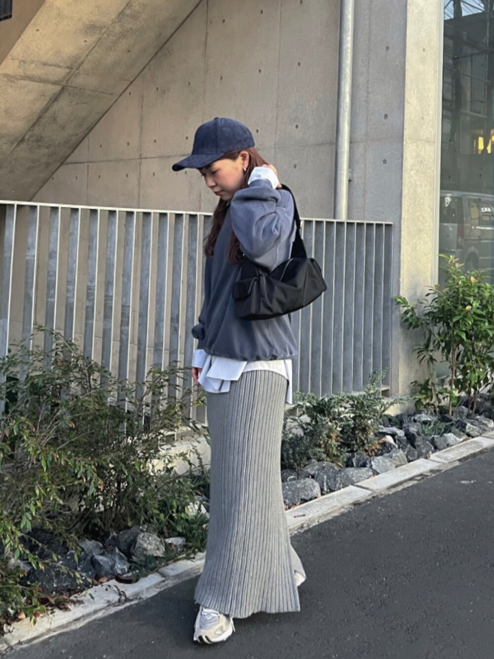 ブルー系のシャツ/ブラウス、グレー系のスカート、グレー系のスニーカーを着用したレディースの秋コーディネートの2枚目の写真