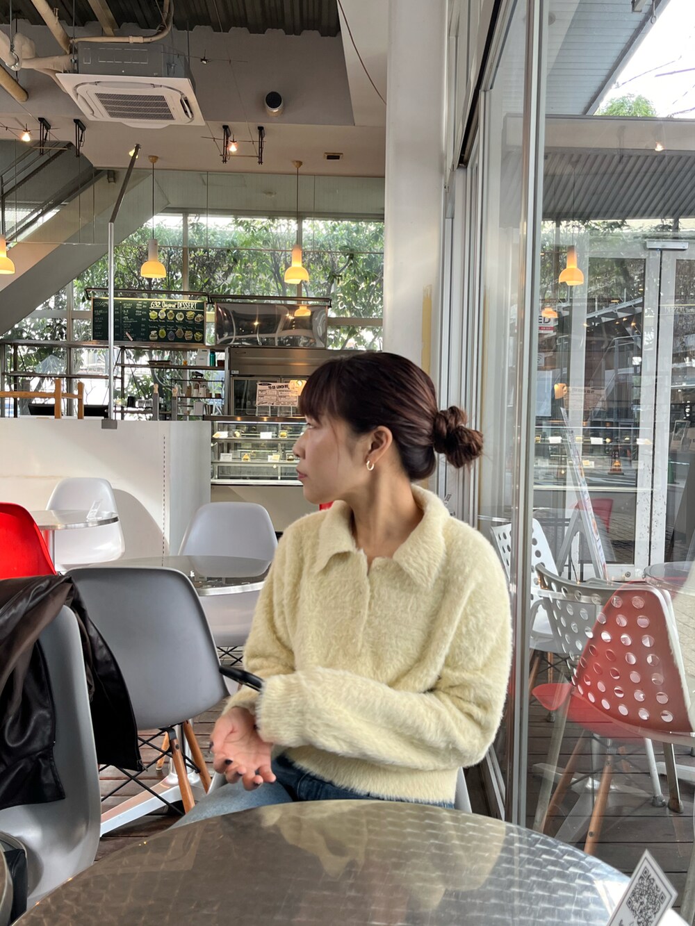 ホワイト系のニット/セーター、ブルー系のデニムパンツ、ベージュ系のショルダーバッグを着用したレディースの冬コーディネートの5枚目の写真