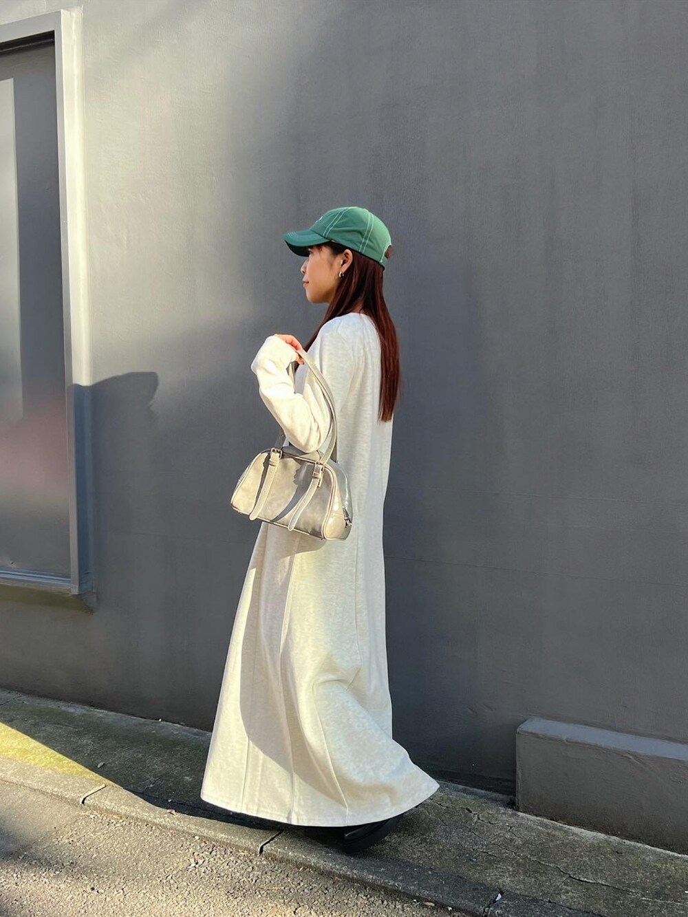 グレー系のワンピース、グレー系のボストンバッグを着用したレディースの冬コーディネートの3枚目の写真