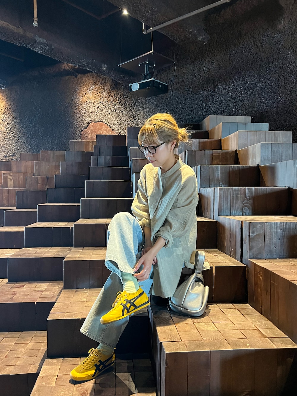 ベージュ系のシャツ/ブラウス、ブルー系のデニムパンツ、シルバー系のハンドバッグを着用したレディースの春コーディネートの3枚目の写真