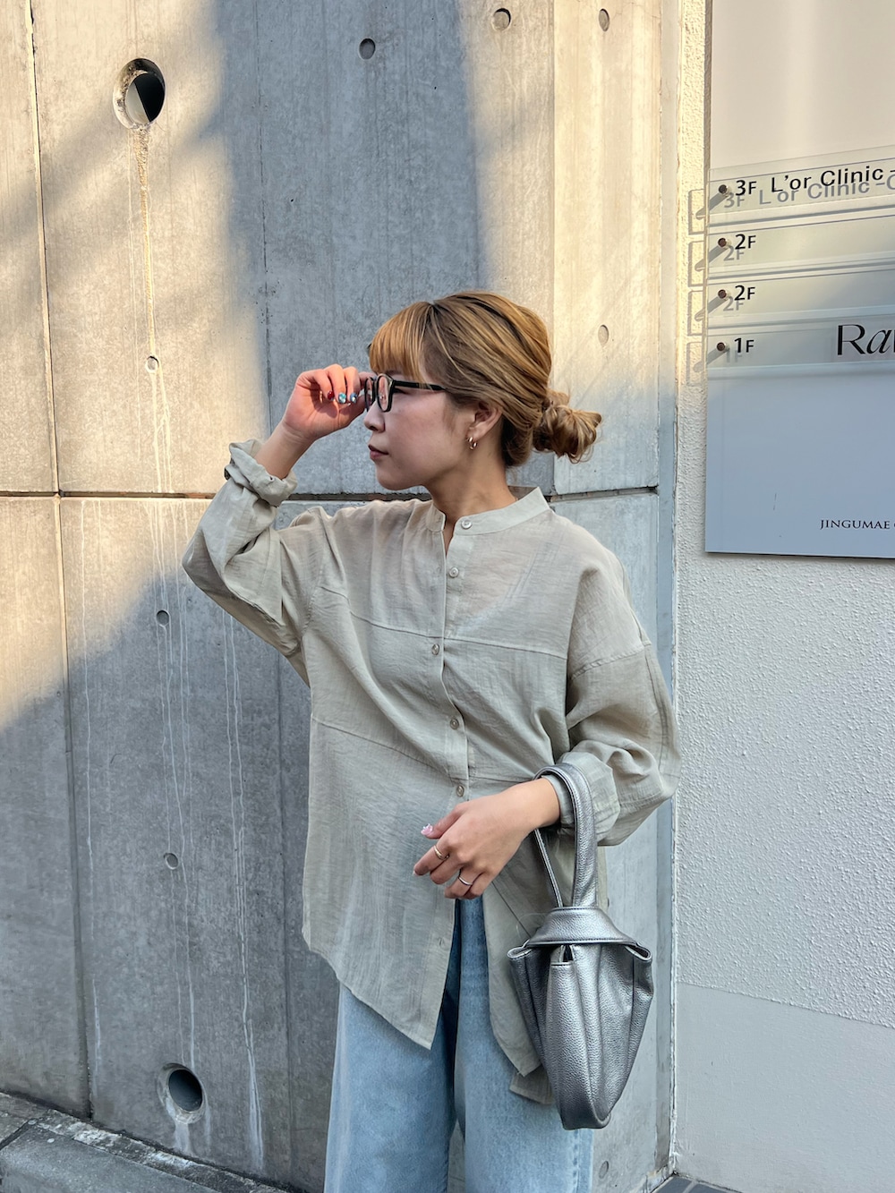 ベージュ系のシャツ/ブラウス、ブルー系のデニムパンツ、シルバー系のハンドバッグを着用したレディースの春コーディネートの4枚目の写真