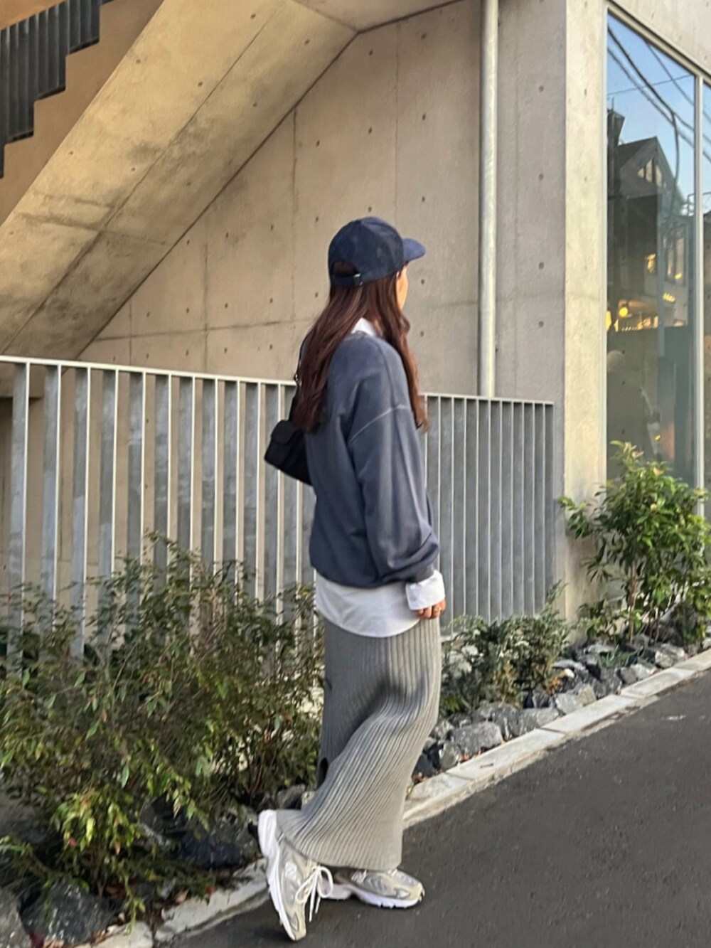 ブルー系のシャツ/ブラウス、グレー系のスカート、グレー系のスニーカーを着用したレディースの秋コーディネートの3枚目の写真