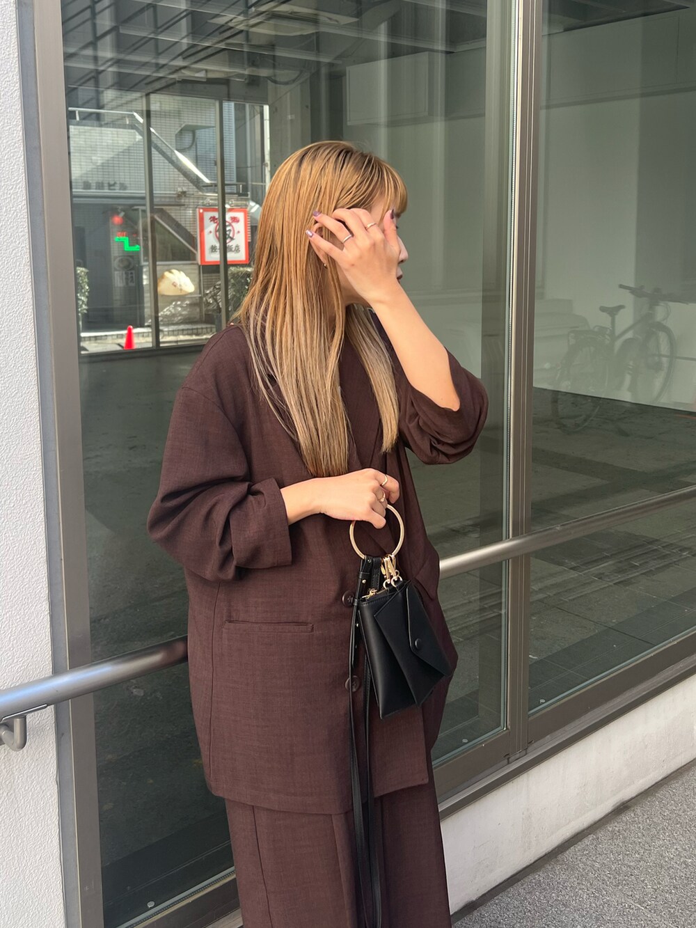 ブラウン系のテーラードジャケット、ブラウン系のその他パンツ、ブラック系のショルダーバッグを着用したレディースの冬コーディネートの5枚目の写真