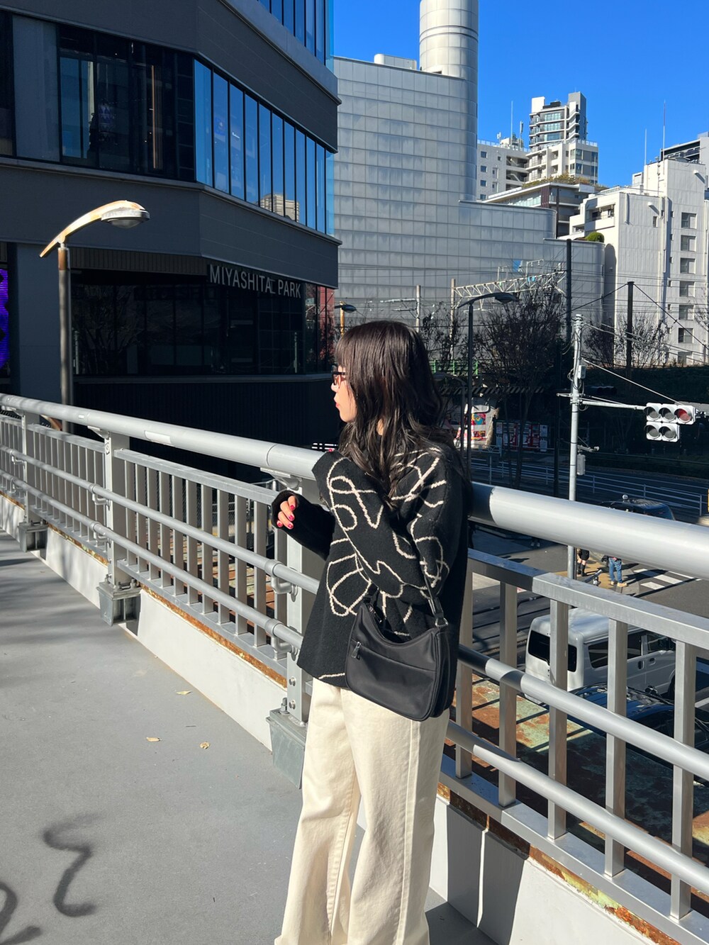 ブラック系のニット/セーター、ブラック系のハンドバッグを着用したレディースの冬コーディネートの2枚目の写真