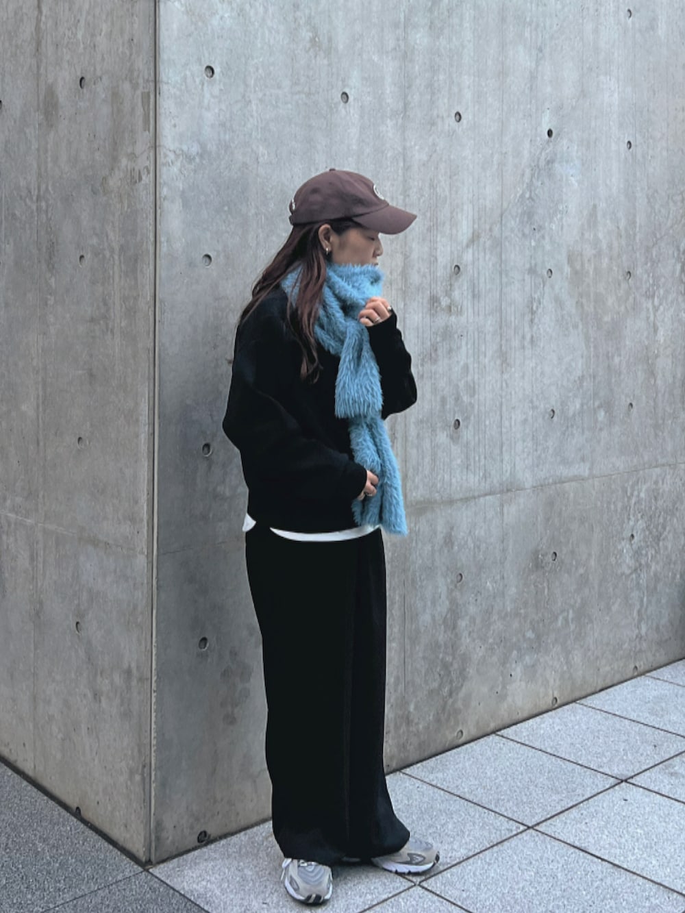 ブラック系のニット/セーター、ブラック系のパンツ、グレー系のスニーカーを着用したレディースの秋コーディネートの2枚目の写真