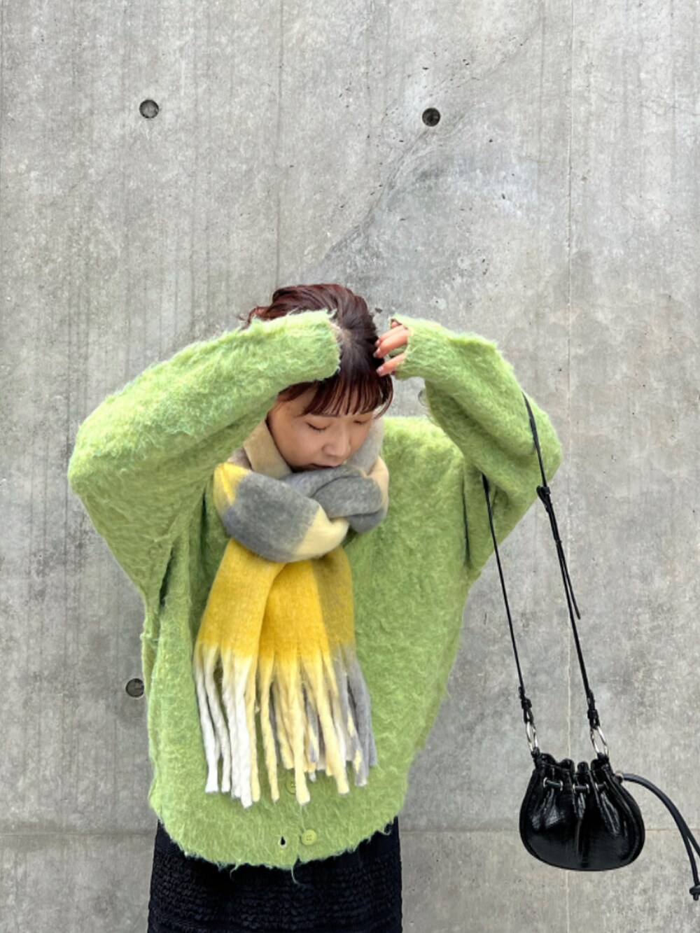 グリーン系のカーディガン/ボレロ、ブラック系のスカート、ブラック系のショルダーバッグを着用したレディースの秋コーディネートの3枚目の写真