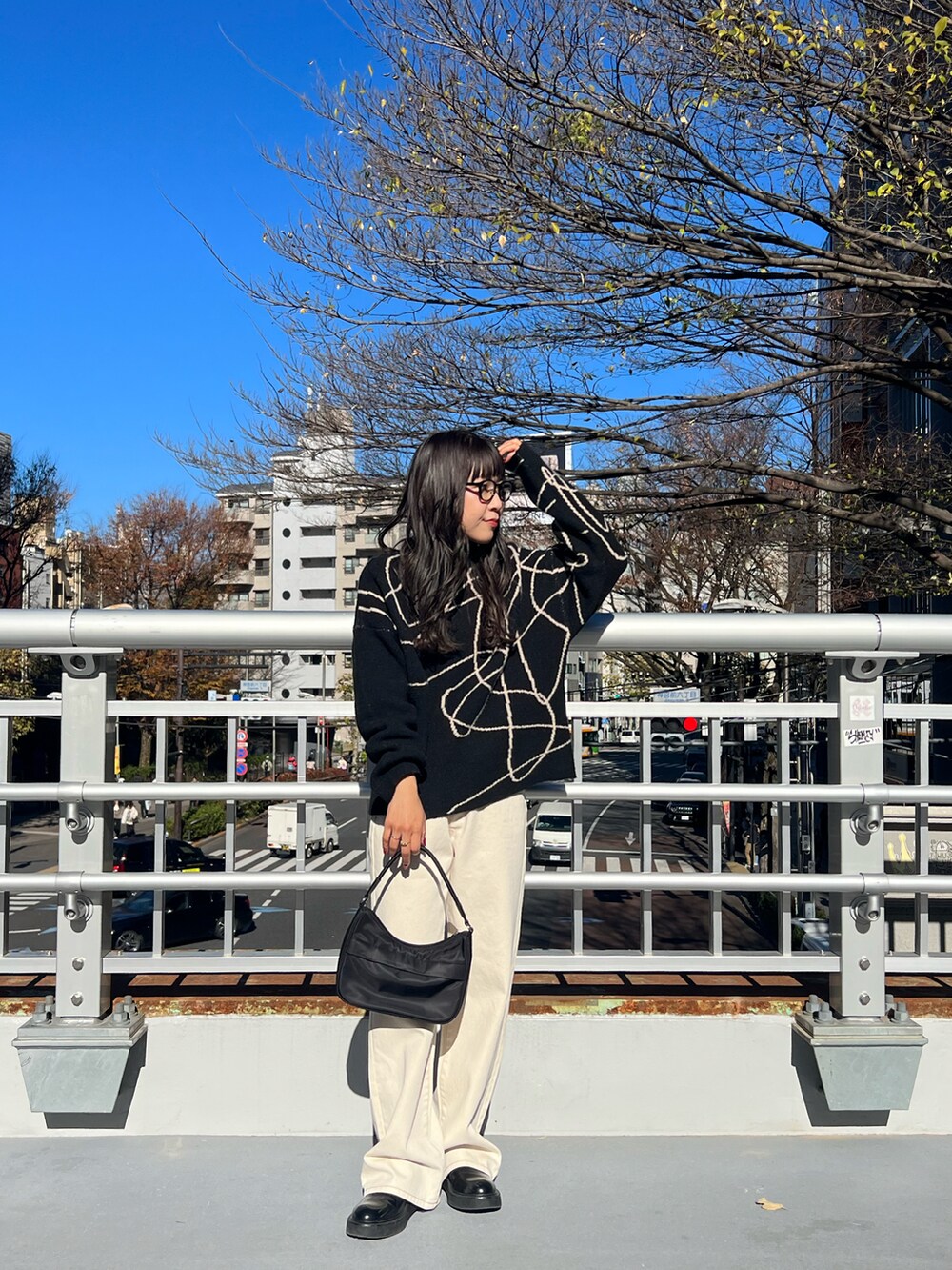 ブラック系のニット/セーター、ブラック系のハンドバッグを着用したレディースの冬コーディネートの3枚目の写真