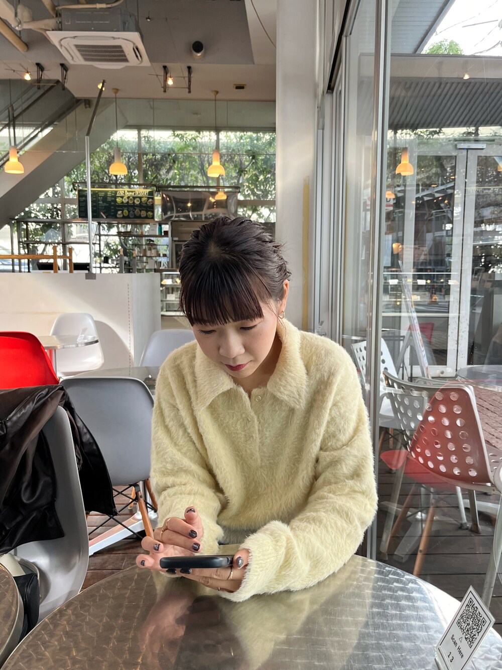 ホワイト系のニット/セーター、ブルー系のデニムパンツ、ベージュ系のショルダーバッグを着用したレディースの冬コーディネートの2枚目の写真