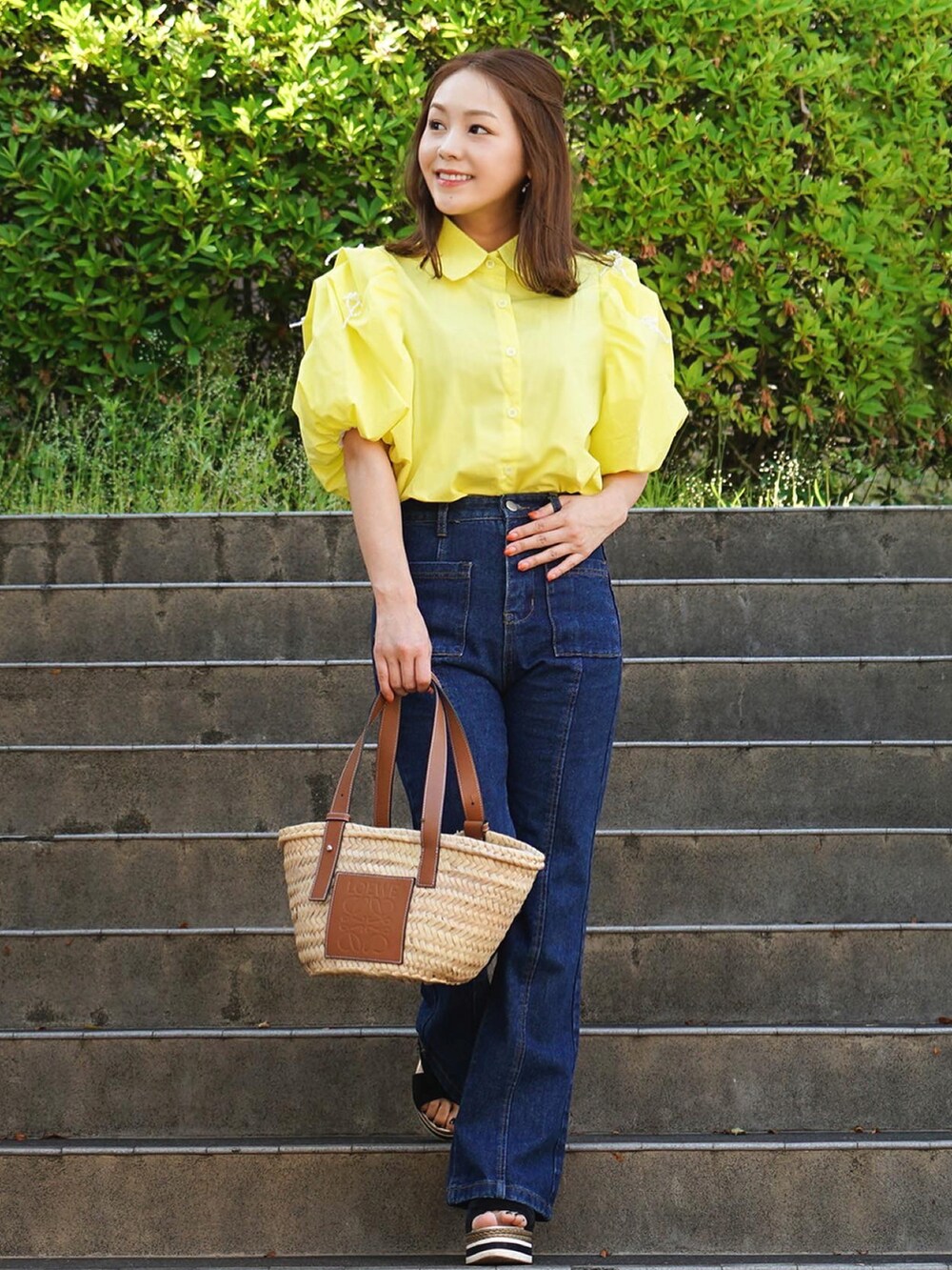 ベージュ系のかごバッグ、イエロー系のシャツ/ブラウスを着用したレディースの夏コーディネートの2枚目の写真