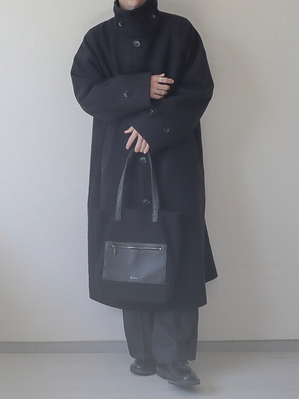 ブラック系のステンカラーコート、ブラック系のスウェット、ブラック系のスラックスを着用したメンズの秋コーディネートの2枚目の写真