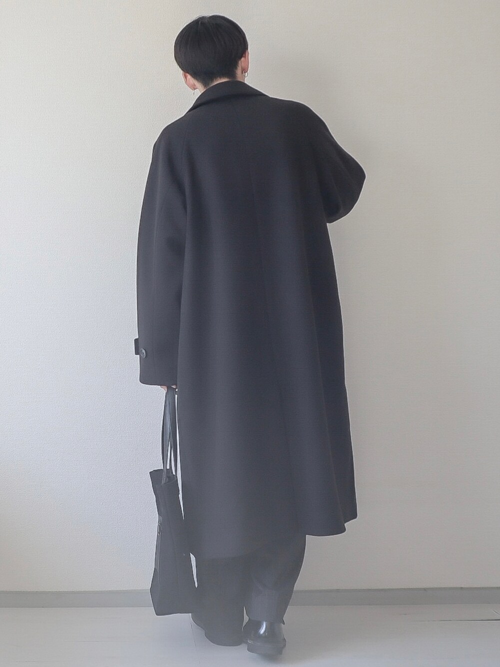 ブラック系のステンカラーコート、ブラック系のスウェット、ブラック系のスラックスを着用したメンズの秋コーディネートの3枚目の写真