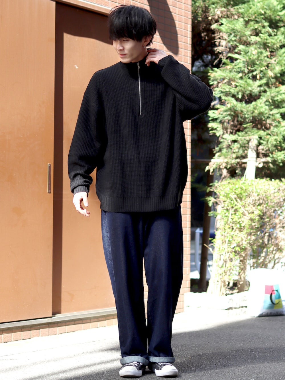 ブラック系のニット/セーター、ブルー系のデニムパンツ、ブラック系のスニーカーを着用したメンズの秋コーディネートの3枚目の写真