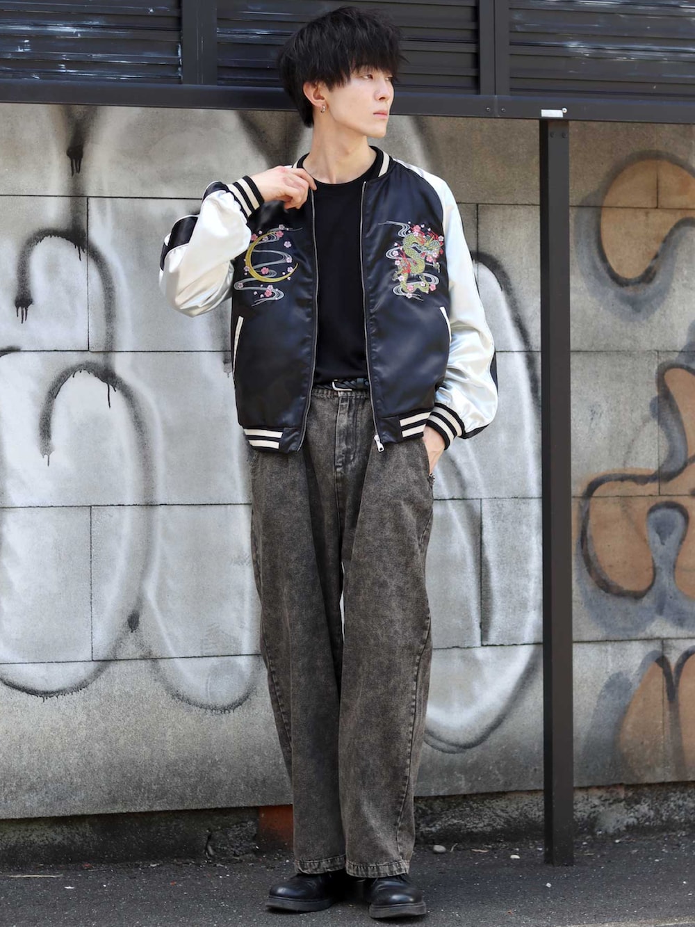 ブラック系のスカジャン、ブラック系のデニムパンツ、ブラック系のドレスシューズを着用したメンズの秋コーディネートの4枚目の写真