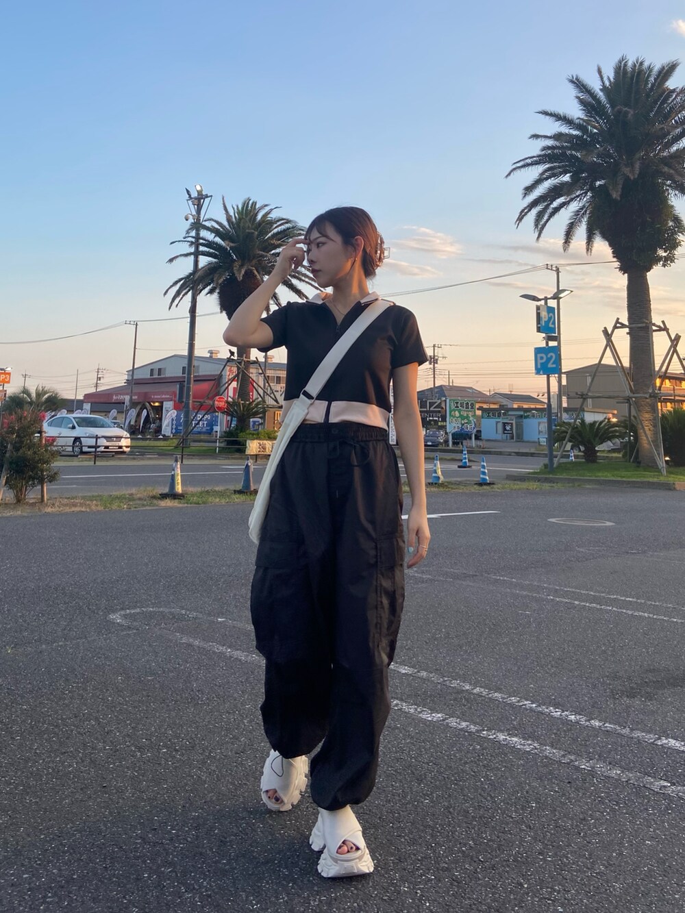 ホワイト系のサンダル、ブラック系のカーゴパンツ、ブラック系のジャージを着用したレディースの夏コーディネートの2枚目の写真