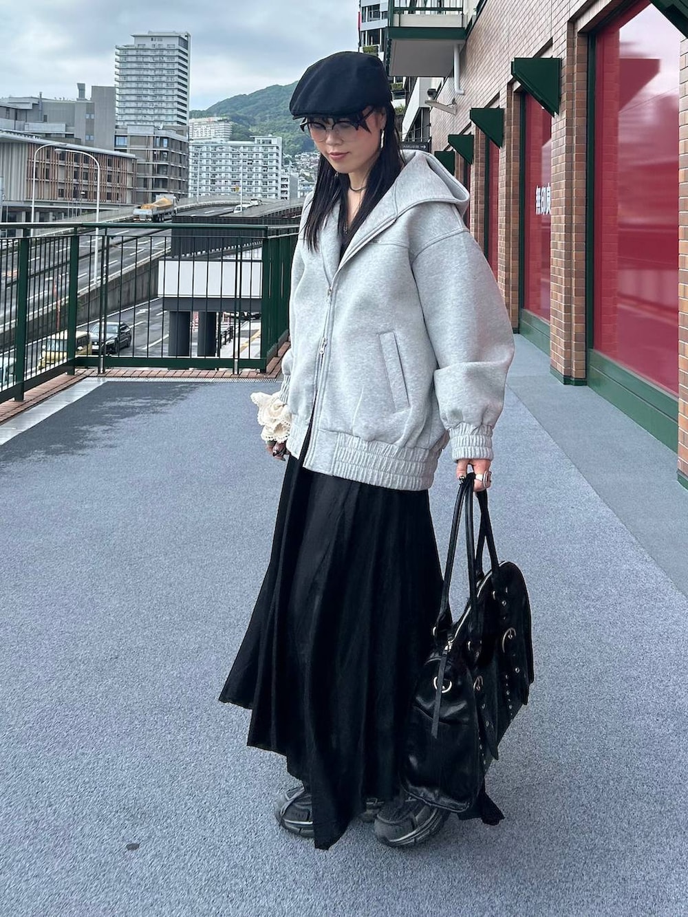 グレー系のパーカー、ブラック系のトートバッグ、ブラック系のキャミソールを着用したレディースの秋コーディネートの2枚目の写真