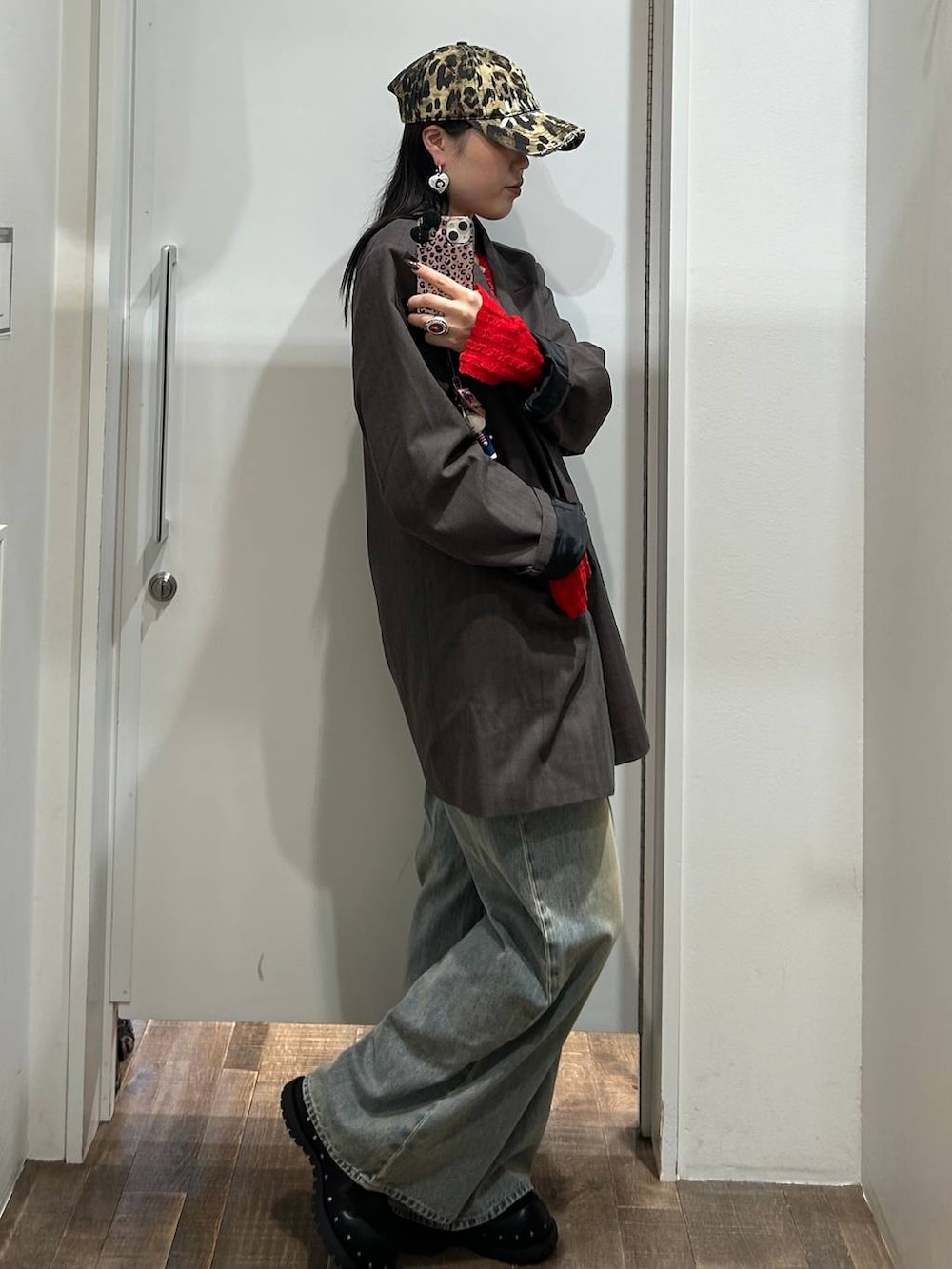 ブルー系のデニムパンツ、グレー系のテーラードジャケット、ブラック系のサンダルを着用したレディースの秋コーディネートの2枚目の写真