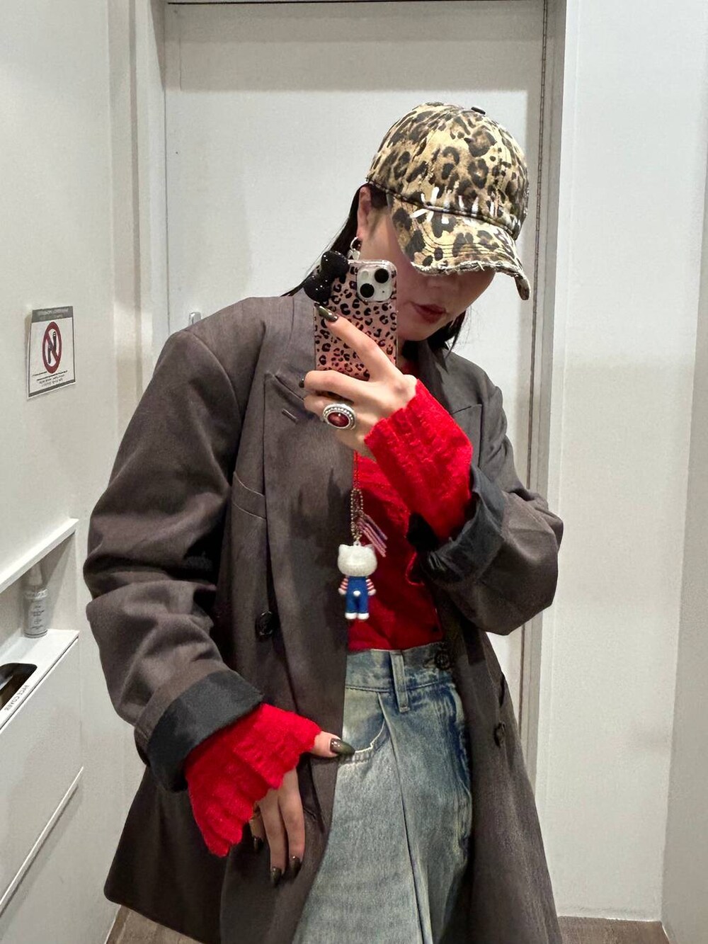 ブルー系のデニムパンツ、グレー系のテーラードジャケット、ブラック系のサンダルを着用したレディースの秋コーディネートの3枚目の写真