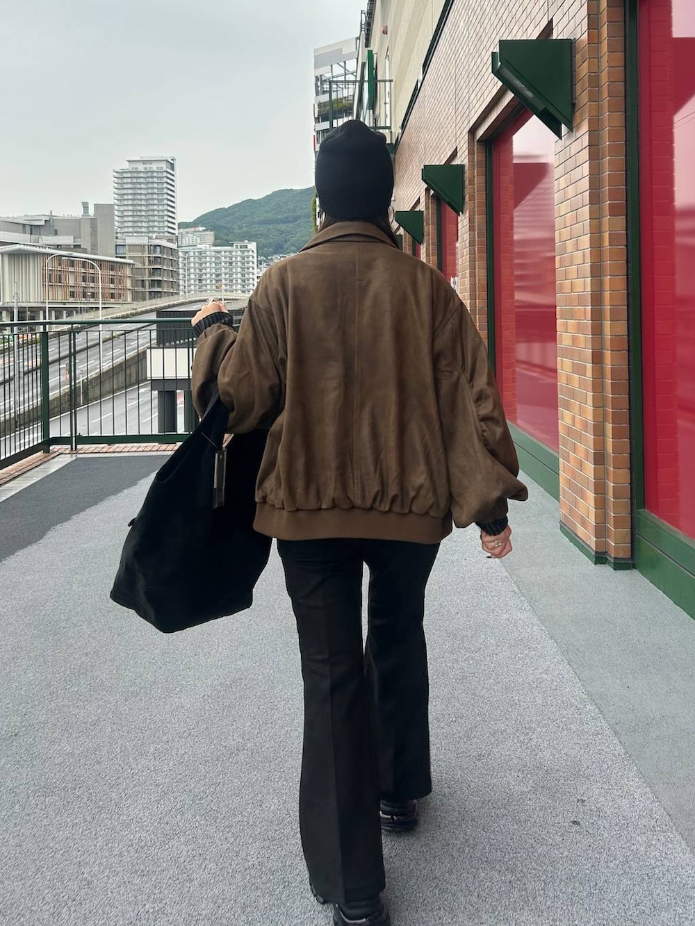 ブラウン系のブルゾン、ブラック系のブーツ、ブラック系のその他パンツを着用したレディースの秋コーディネートの3枚目の写真