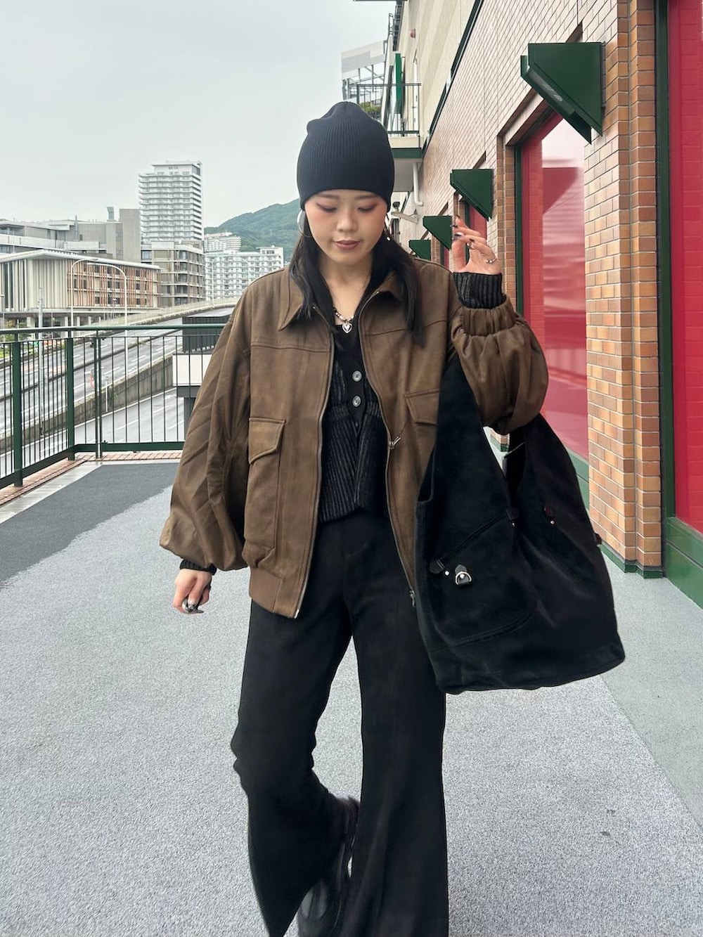 ブラウン系のブルゾン、ブラック系のブーツ、ブラック系のその他パンツを着用したレディースの秋コーディネートの5枚目の写真