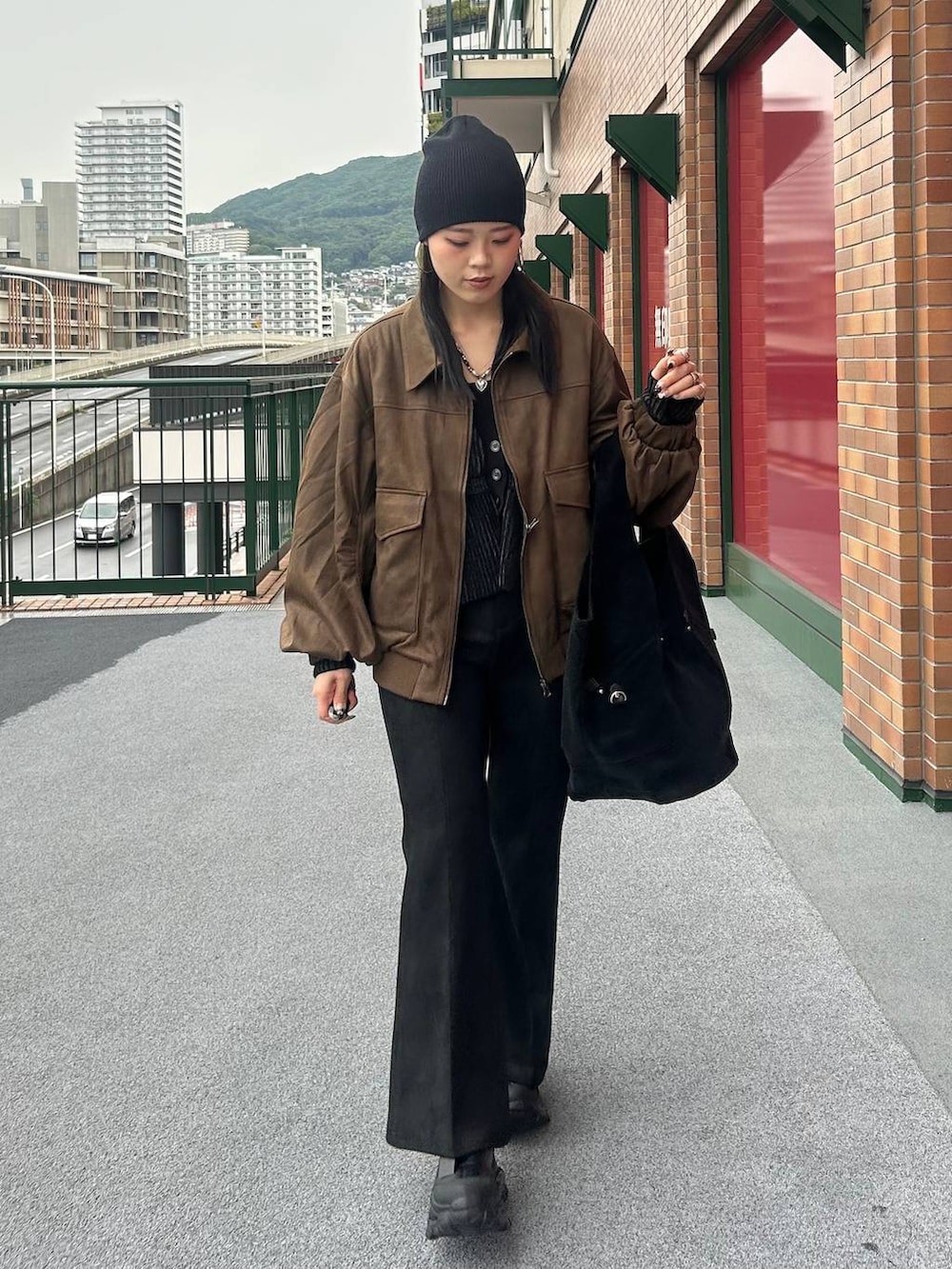 ブラウン系のブルゾン、ブラック系のブーツ、ブラック系のその他パンツを着用したレディースの秋コーディネートの4枚目の写真