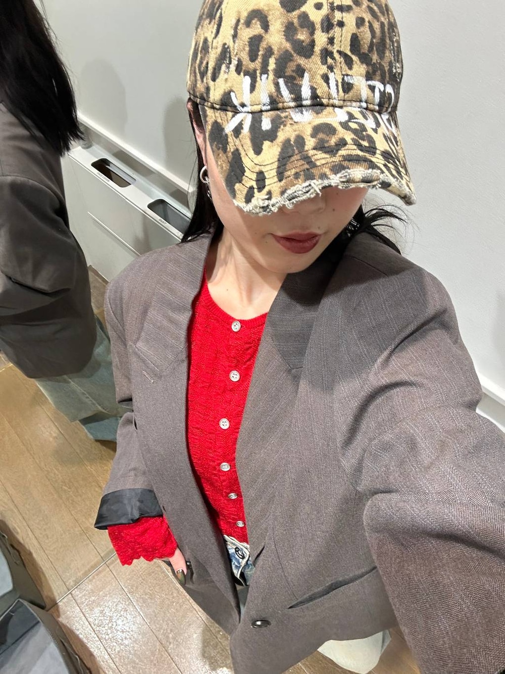 ブルー系のデニムパンツ、グレー系のテーラードジャケット、ブラック系のサンダルを着用したレディースの秋コーディネートの4枚目の写真