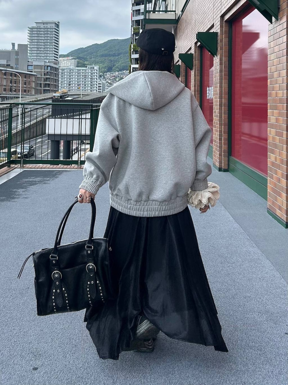 グレー系のパーカー、ブラック系のトートバッグ、ブラック系のキャミソールを着用したレディースの秋コーディネートの3枚目の写真