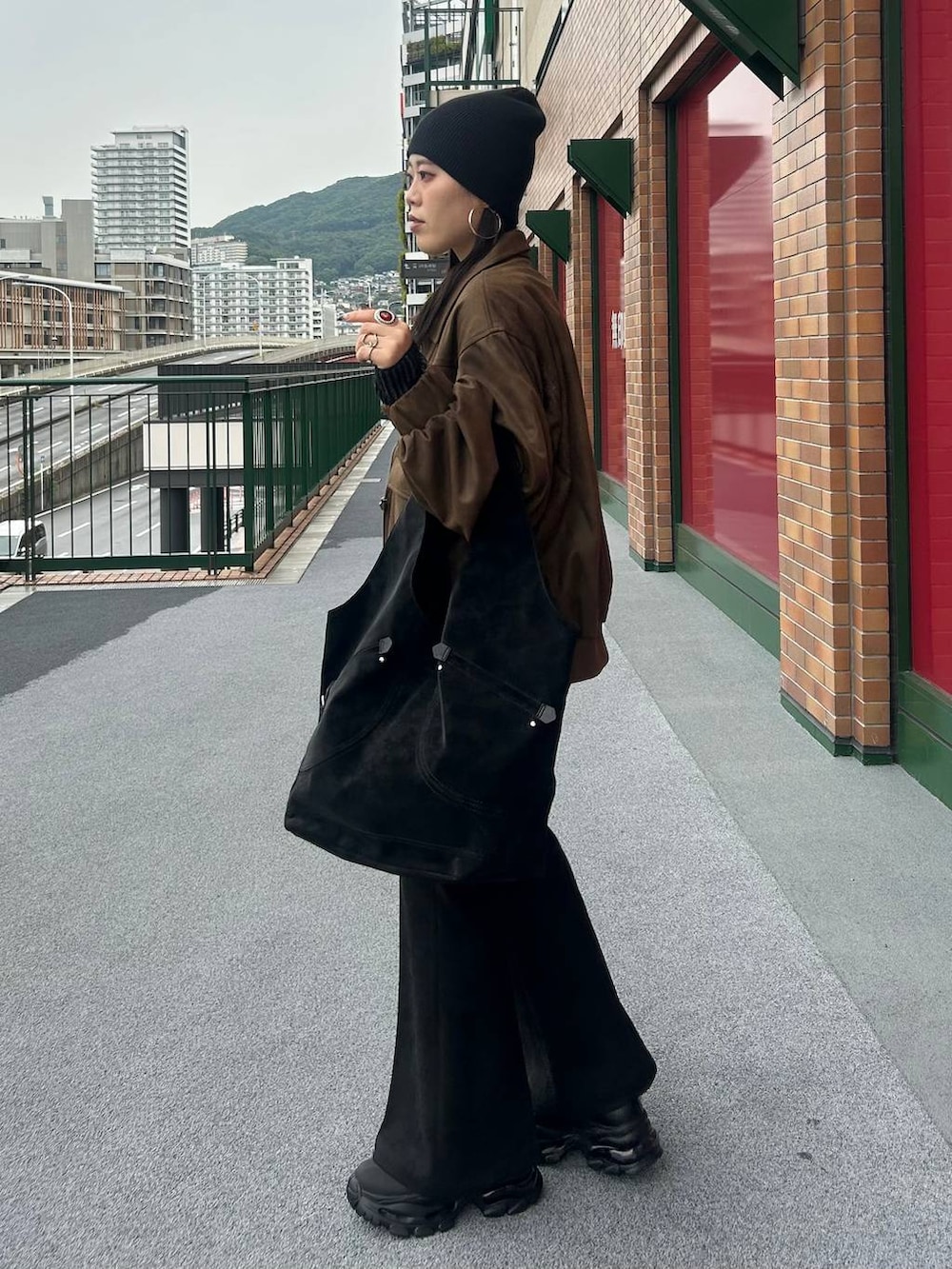 ブラウン系のブルゾン、ブラック系のブーツ、ブラック系のその他パンツを着用したレディースの秋コーディネートの2枚目の写真