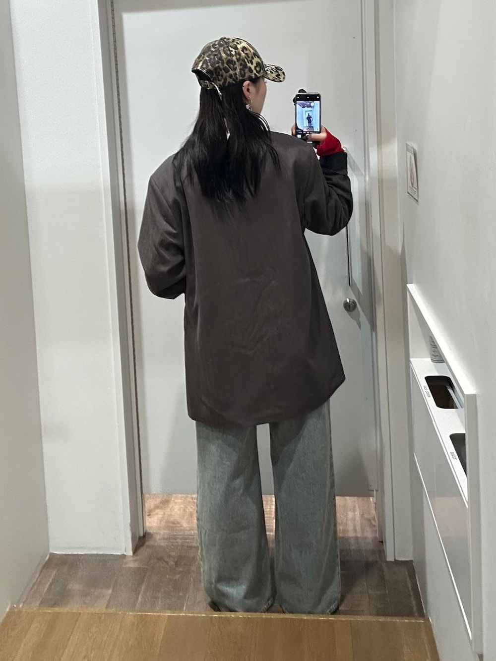 ブルー系のデニムパンツ、グレー系のテーラードジャケット、ブラック系のサンダルを着用したレディースの秋コーディネートの6枚目の写真