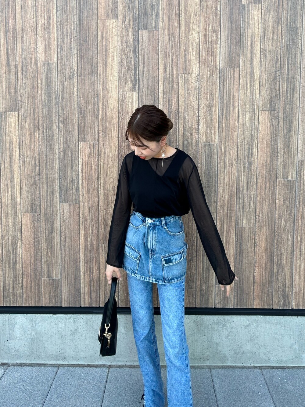 ブルー系のデニムパンツ、ブラック系のブーツ、ブルー系のデニムスカートを着用したレディースの秋コーディネートの2枚目の写真