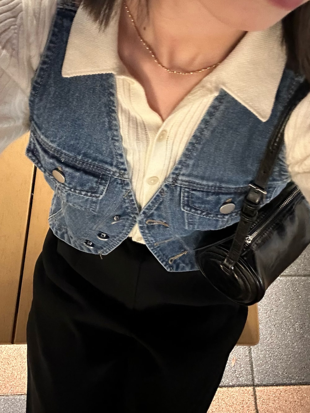 ホワイト系のニット/セーター、ブラック系のハンドバッグ、ブラック系のベルトを着用したレディースの秋コーディネートの2枚目の写真