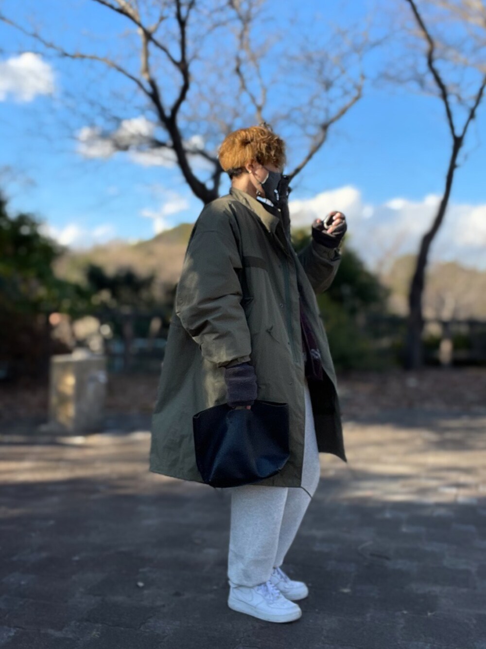 ブラウン系のカーディガン/ボレロ、ベージュ系のTシャツ/カットソー、グリーン系のモッズコートを着用したメンズの冬コーディネートの2枚目の写真