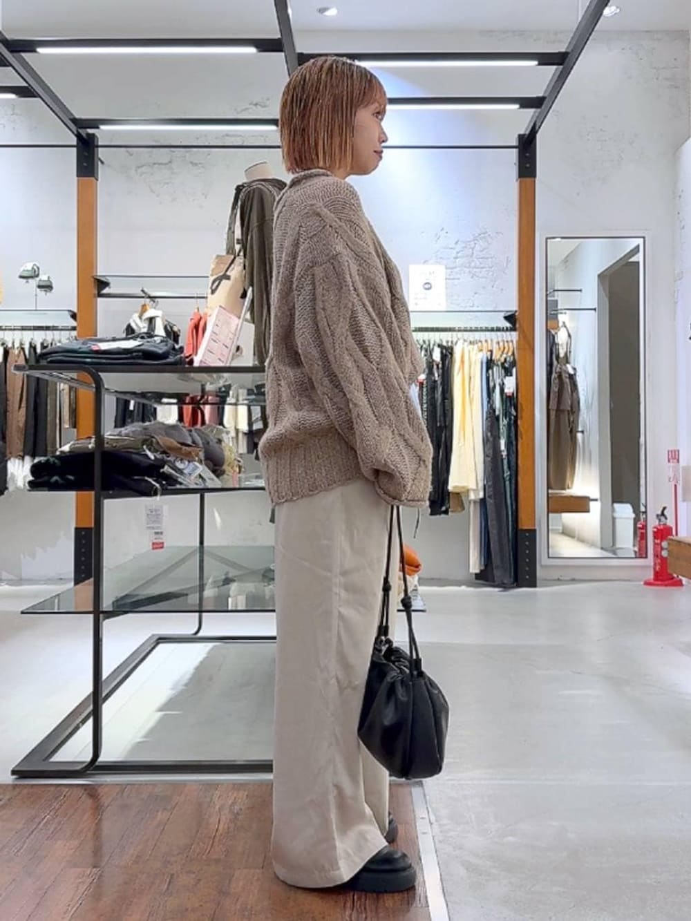 ホワイト系のその他パンツ、ブラック系のショルダーバッグ、シルバー系のネックレスを着用したレディースの秋コーディネートの2枚目の写真