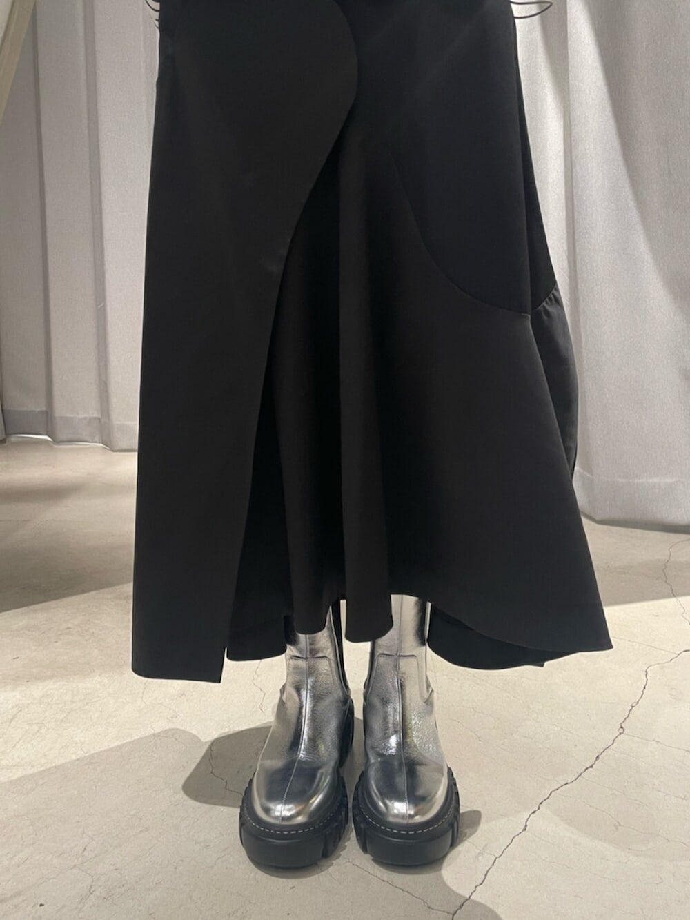 ブラック系のスカート、シルバー系のブーツ、その他のTシャツ/カットソーを着用したレディースの冬コーディネートの10枚目の写真