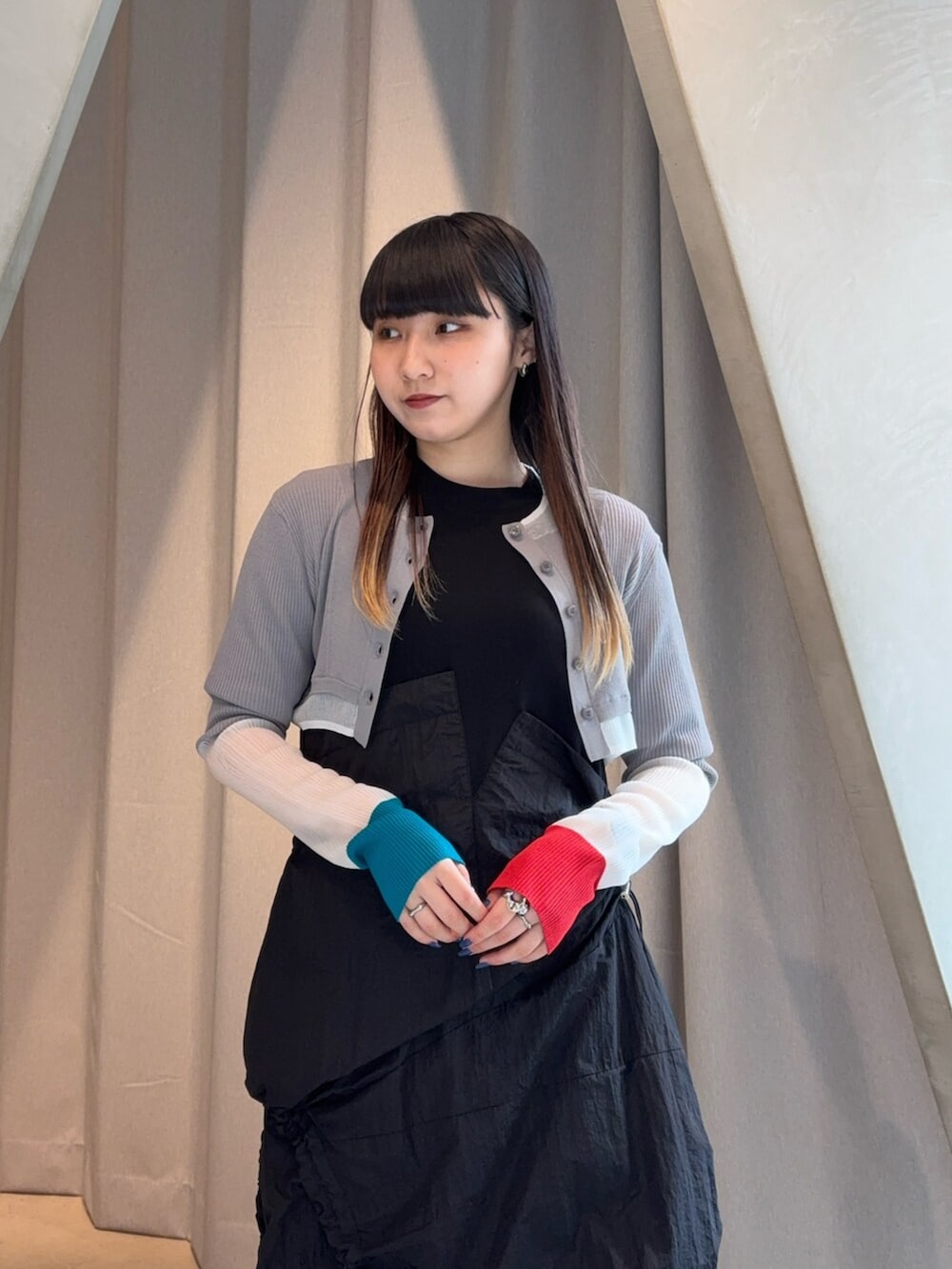 シルバー系のブーツ、ブラック系のワンピース、グレー系のカーディガン/ボレロを着用したレディースの春コーディネートの4枚目の写真