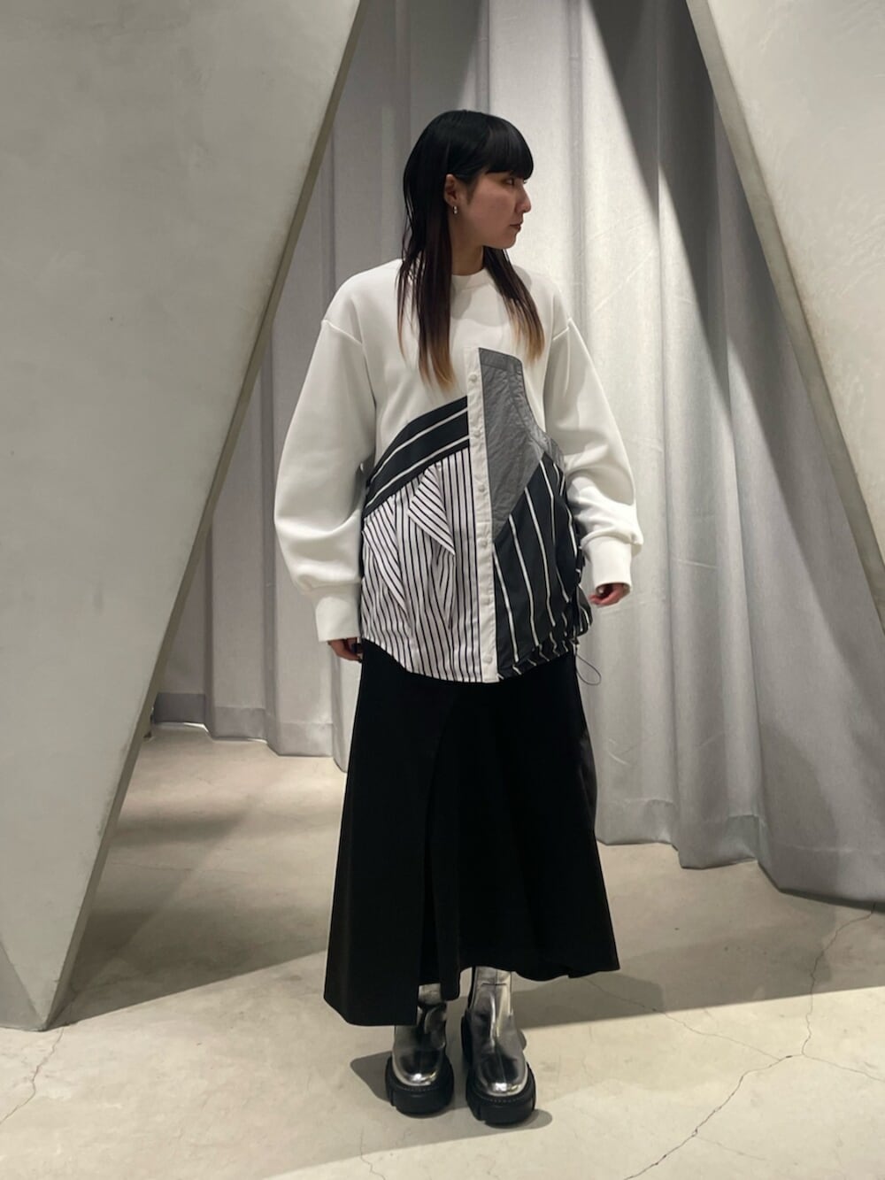 ブラック系のスカート、シルバー系のブーツ、その他のTシャツ/カットソーを着用したレディースの冬コーディネートの5枚目の写真