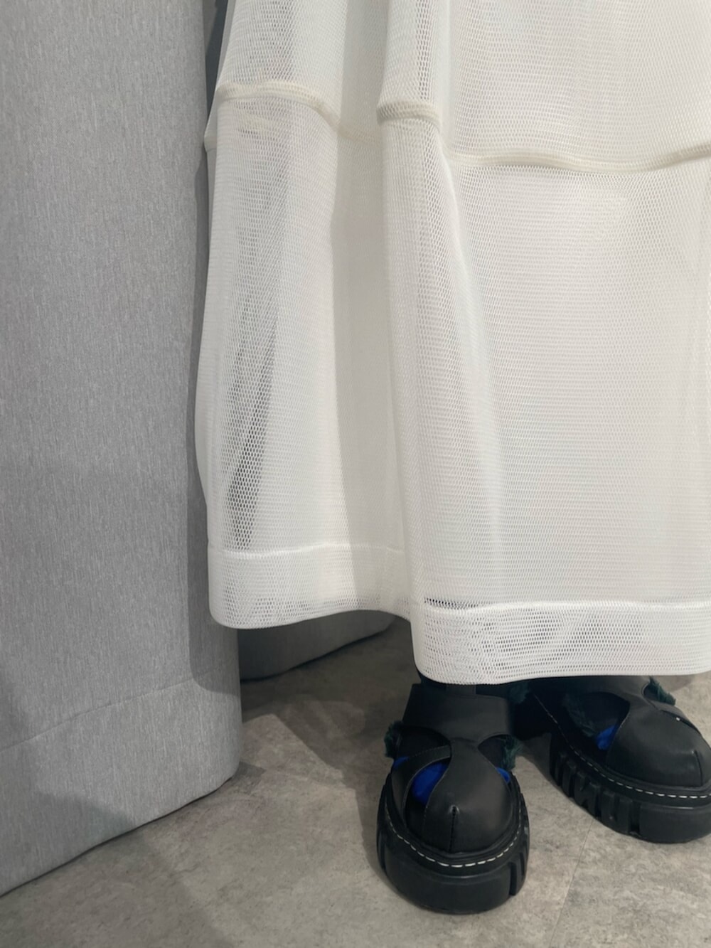 ブラック系のTシャツ/カットソー、ホワイト系のスカート、ブラック系のサンダルを着用したレディースの冬コーディネートの6枚目の写真