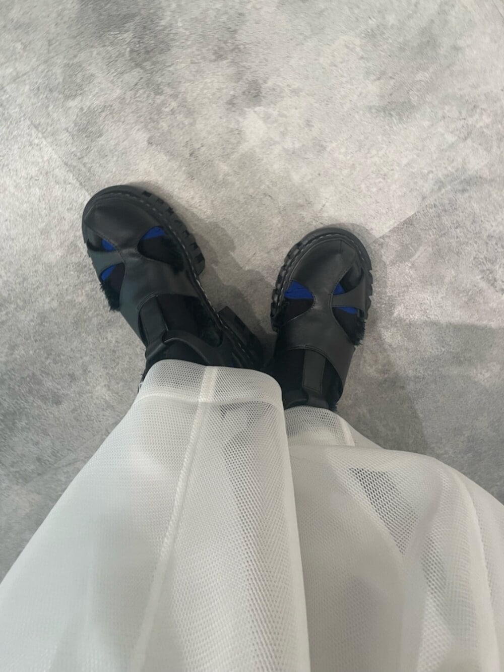 ブラック系のTシャツ/カットソー、ホワイト系のスカート、ブラック系のサンダルを着用したレディースの冬コーディネートの7枚目の写真