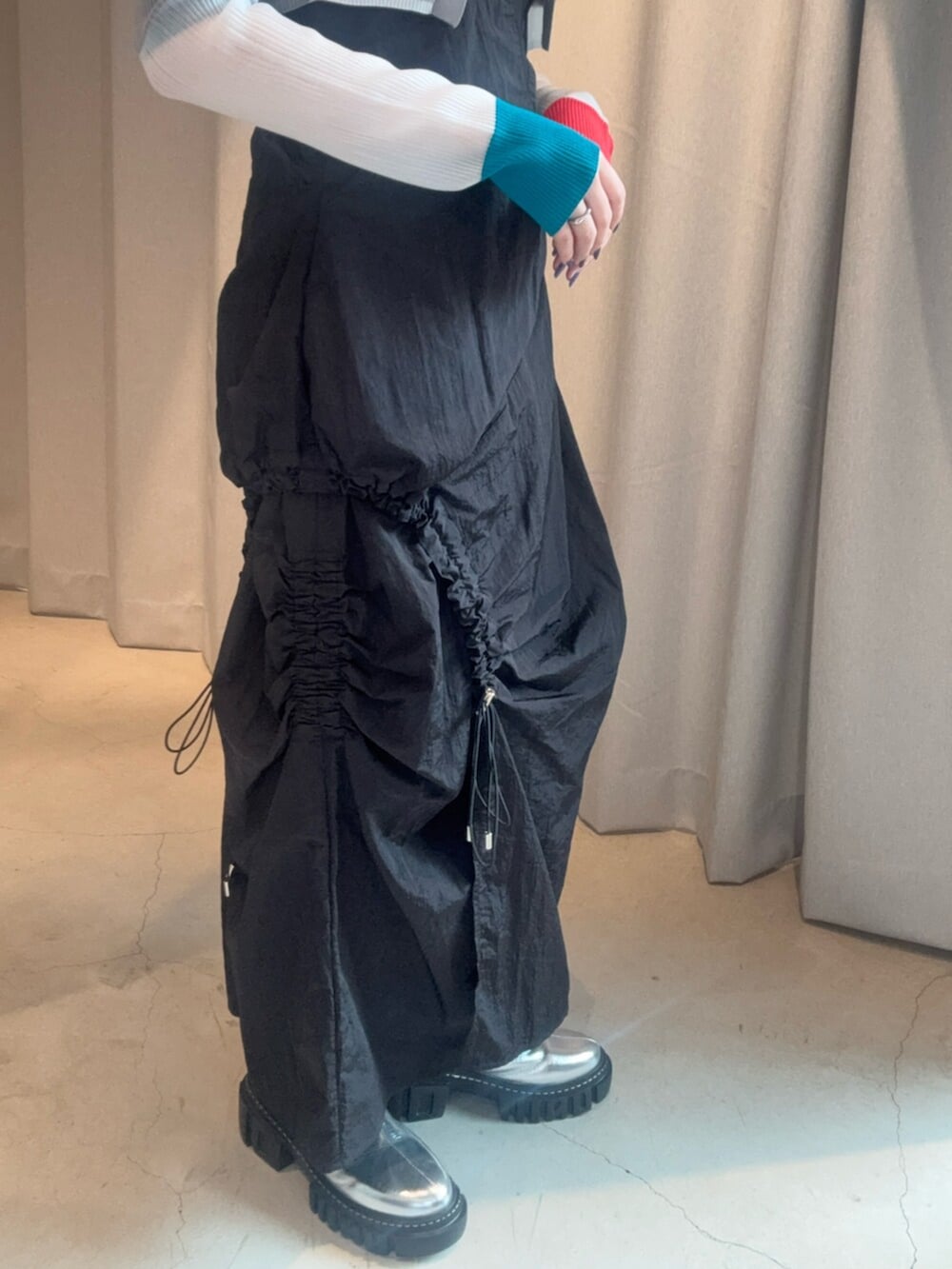 シルバー系のブーツ、ブラック系のワンピース、グレー系のカーディガン/ボレロを着用したレディースの春コーディネートの7枚目の写真