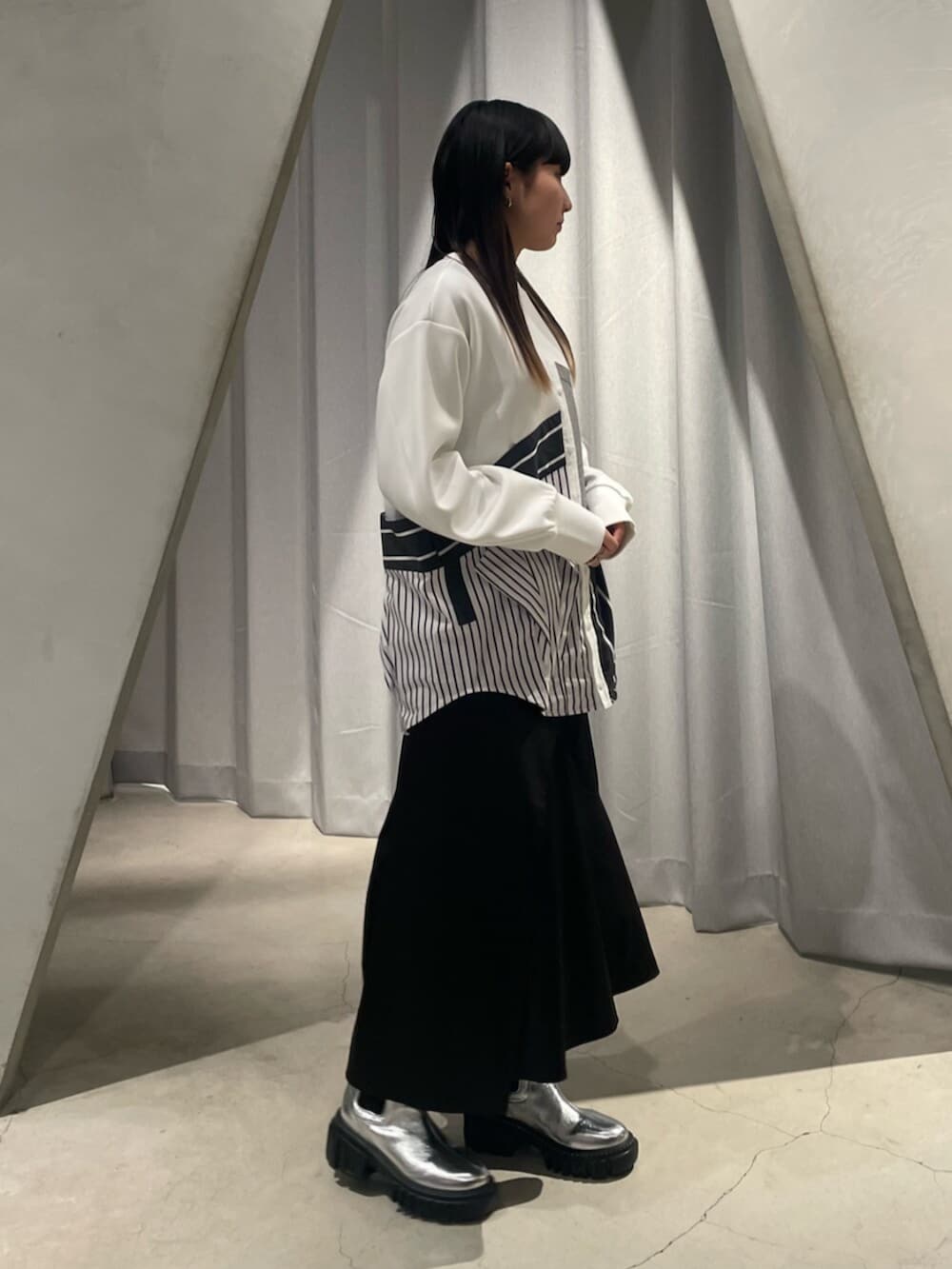 ブラック系のスカート、シルバー系のブーツ、その他のTシャツ/カットソーを着用したレディースの冬コーディネートの4枚目の写真