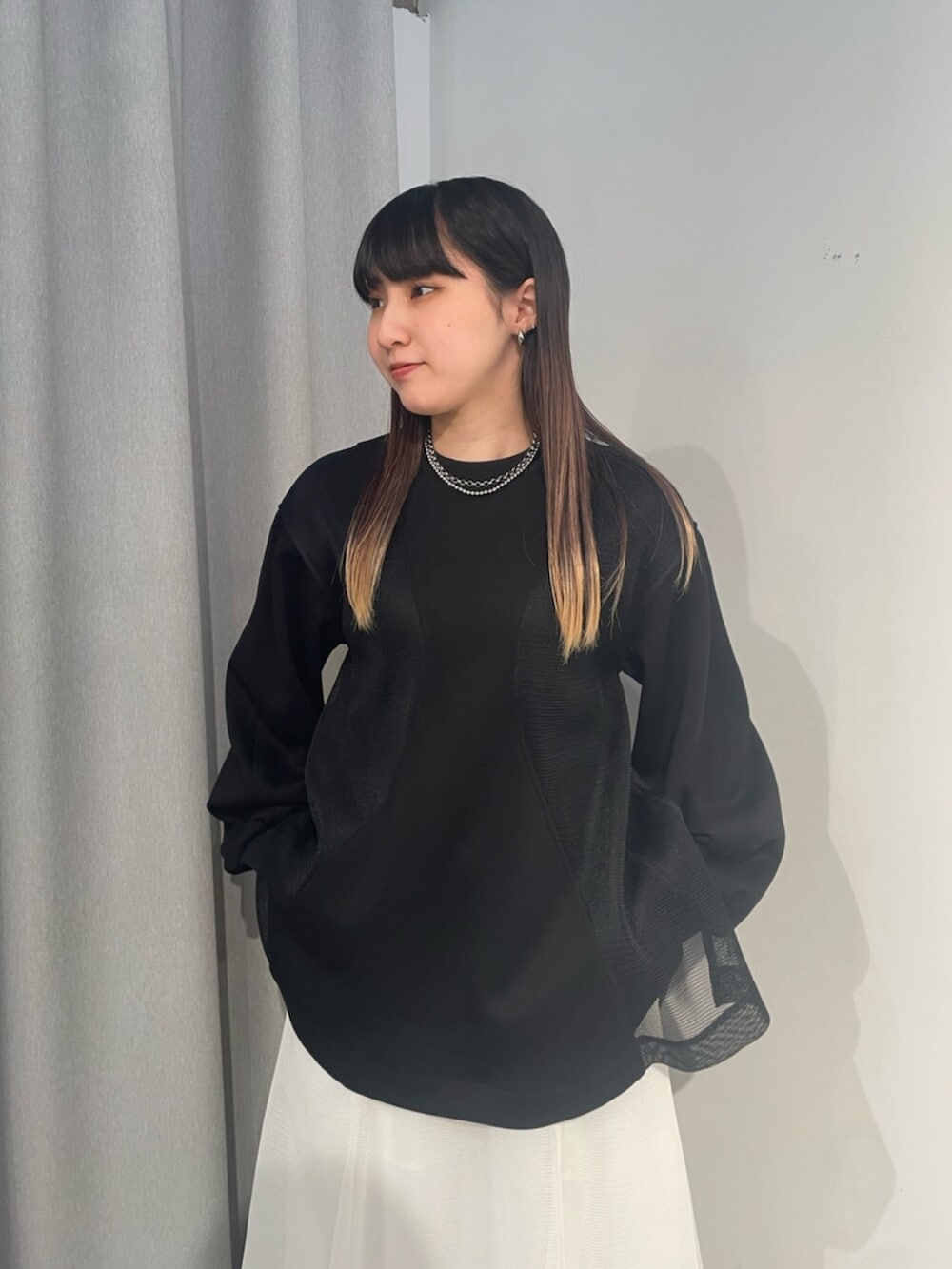 ブラック系のTシャツ/カットソー、ホワイト系のスカート、ブラック系のサンダルを着用したレディースの冬コーディネートの4枚目の写真