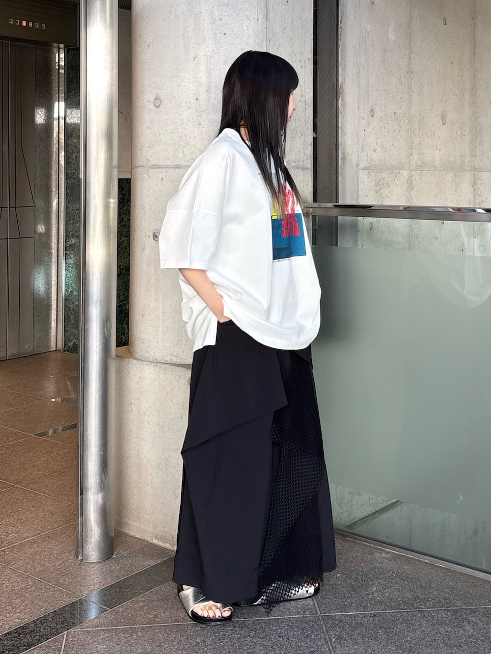 シルバー系のサンダル、ホワイト系のTシャツ/カットソー、ブラック系のスカートを着用したレディースの春コーディネートの4枚目の写真
