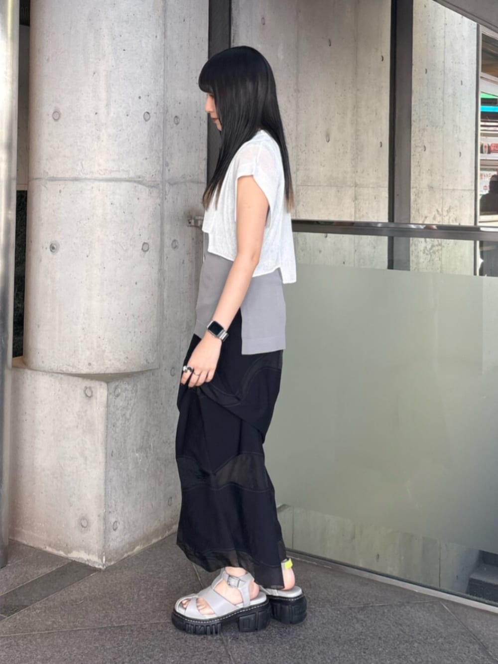 グレー系のサンダル、グレー系のタンクトップ、ホワイト系のニット/セーターを着用したレディースの夏コーディネートの2枚目の写真