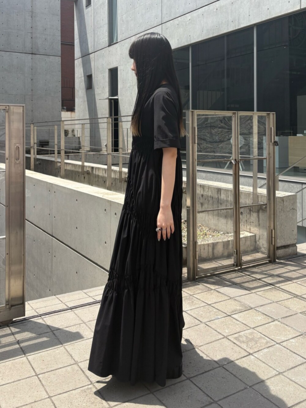 ブラック系のサンダル、ブラック系のワンピースを着用したレディースの夏コーディネートの2枚目の写真