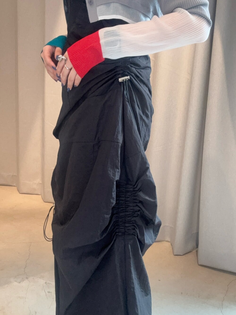 シルバー系のブーツ、ブラック系のワンピース、グレー系のカーディガン/ボレロを着用したレディースの春コーディネートの6枚目の写真