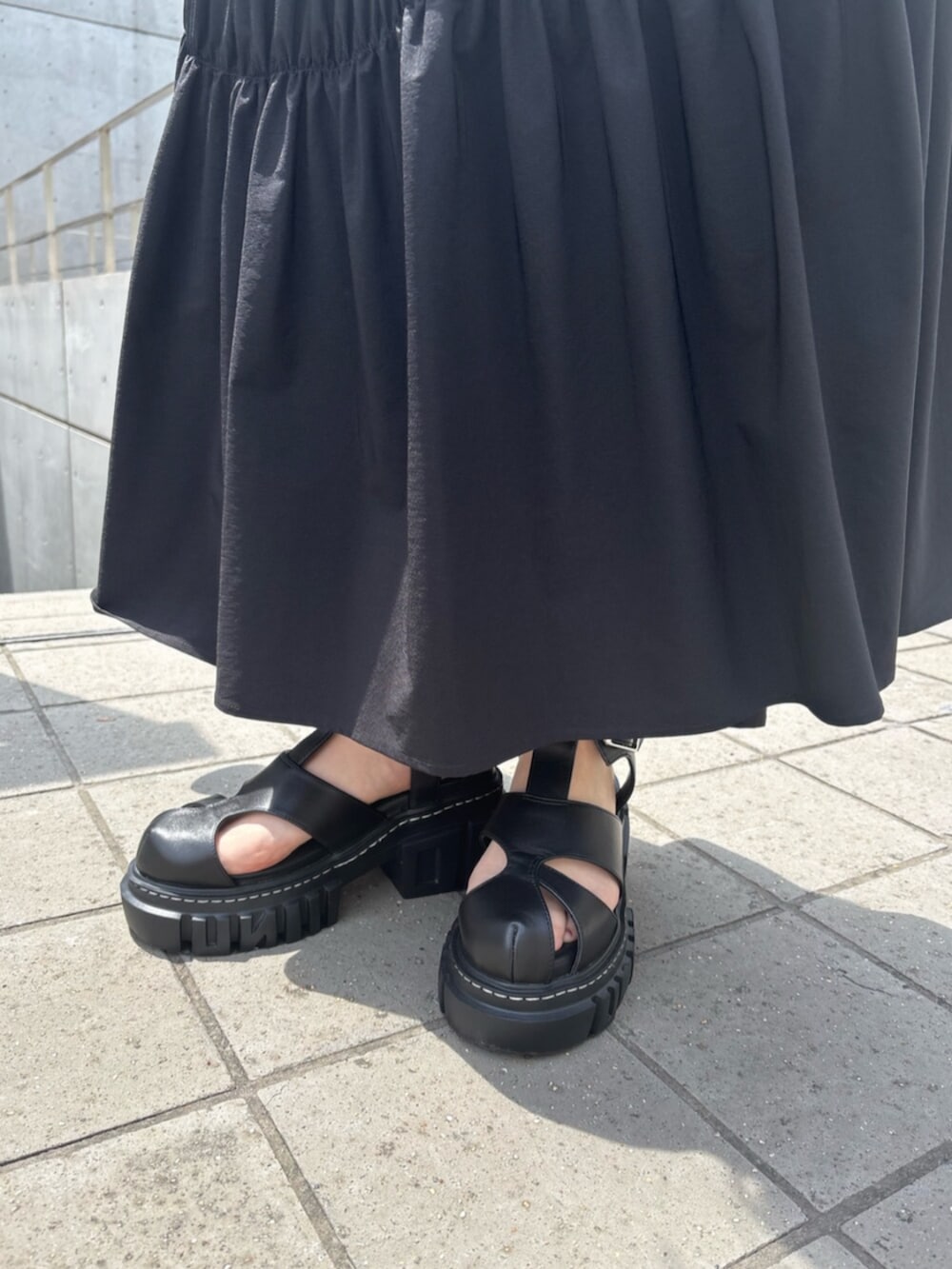 ブラック系のサンダル、ブラック系のワンピースを着用したレディースの夏コーディネートの6枚目の写真